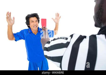 Serious referee showing red ard to player on white background Stock Photo