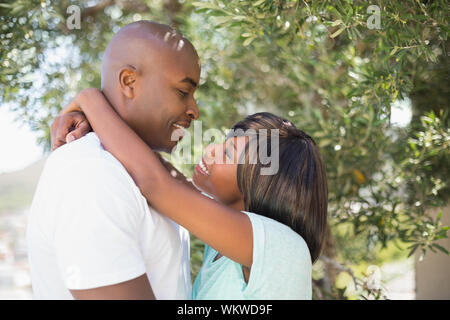 Happy couple hugging each other in garden on a sunny day Stock Photo