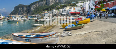 ISLE OF CAPRI, ITALY - AUGUST 2019: Panoramic view of small wooden fishing boats out of the water on the seafront of the port on the Isle of Capri. Stock Photo