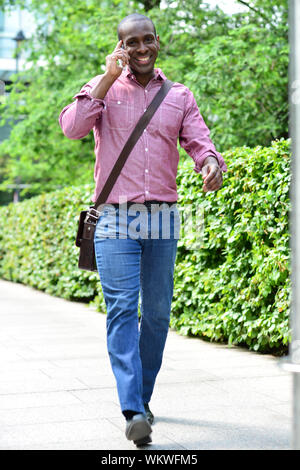 Handsome man walking and talking on the phone Stock Photo