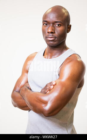 Portrait of a serious muscular man with arms crossed over white background Stock Photo