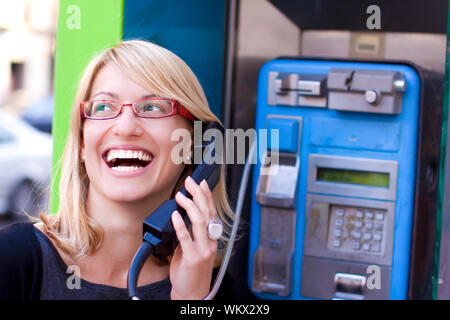 Woman talking on the phone in a retro phone boot Stock Photo
