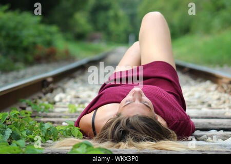 Woman Lying On Railroad Tracks