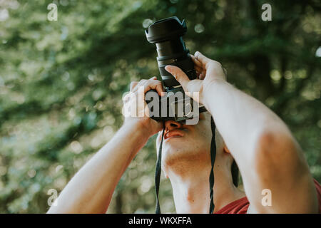 photographer taking photo of wildlife, man with camera setting up a tripod Stock Photo