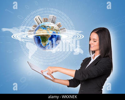 Beautiful businesswoman in suit using tablet. Earth with buildings and world map. Element of this image furnished by NASA Stock Photo