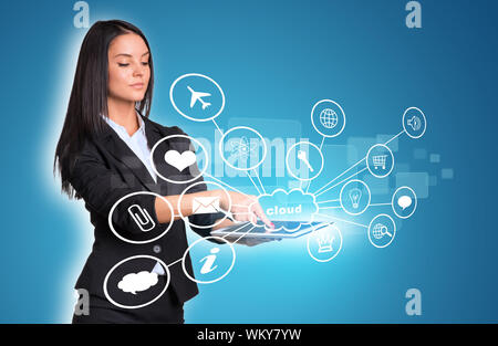Beautiful businesswomen in suit using digital tablet. Cloud with icons. Blue background Stock Photo