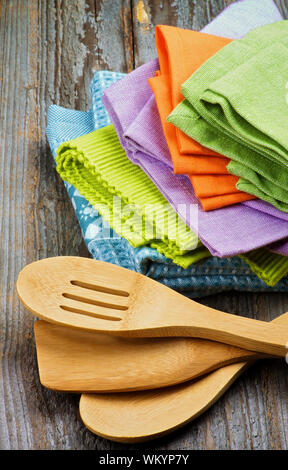 Arrangement of Multi Colored Cloth Napkins and Kitchen Spoons isolated on Rustic Wooden background Stock Photo