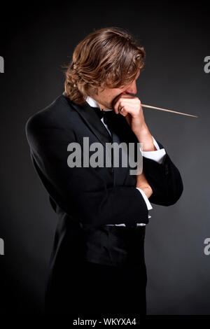 Young Conductor Holding a  Baton Thinking Stock Photo