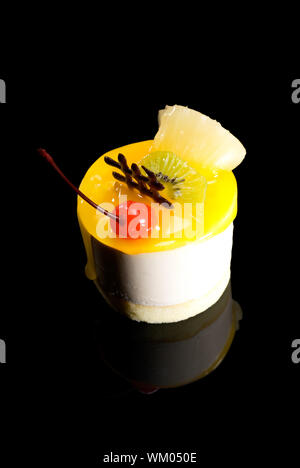 piece of fresh fruit cake close up over black reflective surface Stock Photo