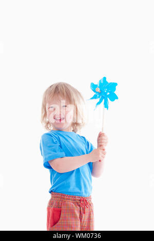 studio shot of a boy playing with pinwheel - isolated on white Stock Photo