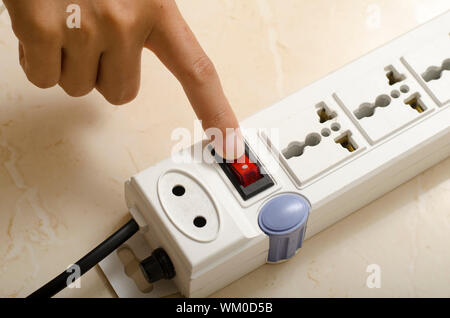 hand turn on switch multiple  socket plug Stock Photo