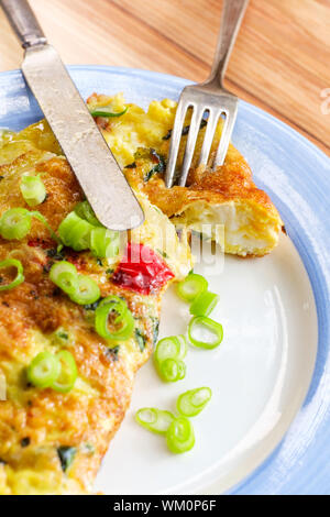 Spanish breakfast omelette filled with cheese spinach onions and peppers Stock Photo