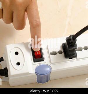 hand turn on switch multiple  socket plug Stock Photo