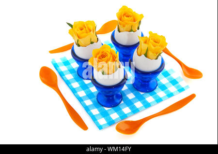 Easter flowers in egg cups with plastic spoons Stock Photo