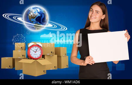 Businesswoman hold paper sheet. Earth and heap of cardboard boxes with alarm clock as backdrop. Element of this image furnished by NASA Stock Photo