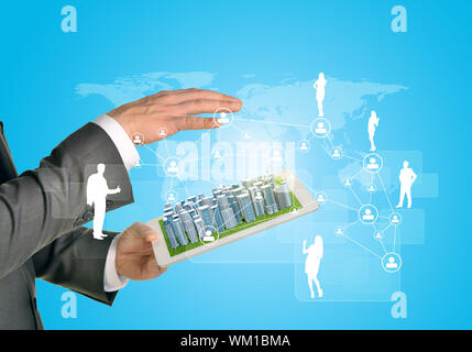 Man hands using tablet pc. Business city on touch screen. Network with business silhouettes near tablet Stock Photo