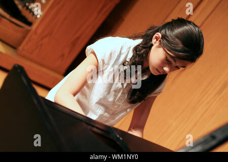 Young teen girl playing piano Stock Photo