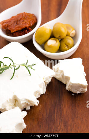 Feta cheese with olives, sun dried tomatoes and fresh herbs Stock Photo
