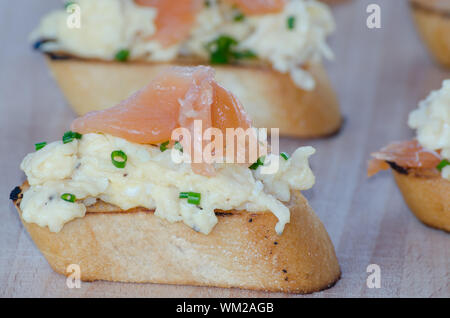 Toast with smoked salmon with scrambled eggs on wood plate Stock Photo