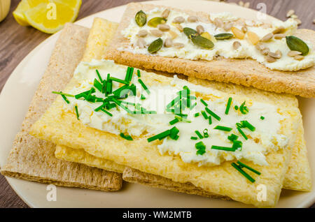 Crisp Crispbread with curd cheese spread with chives and seeds, fried egg and morning tea Stock Photo
