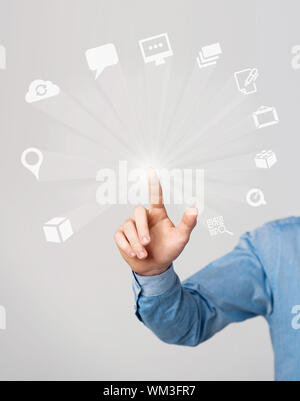 Human hand pressing modern media icons on virtual screen Stock Photo