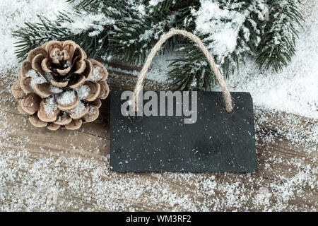 Black board of slate on old rustic wooden background, with snow Stock Photo