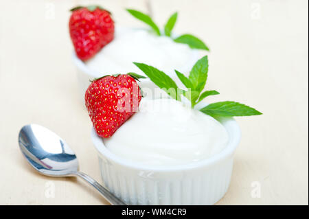 organic Greek yogurt and strawberry over white rustic wood table Stock Photo