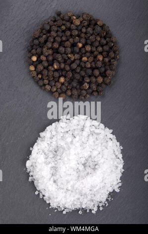 black pepper and coarse salt on slate Stock Photo