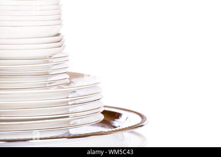 Stack of white dishes on silver platter Stock Photo