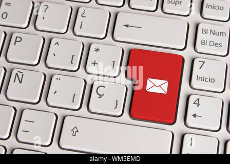 Spanish keyboard with email concept mail envelope icon over red background button. Image with clipping path for easy change the key color and editing. Stock Photo
