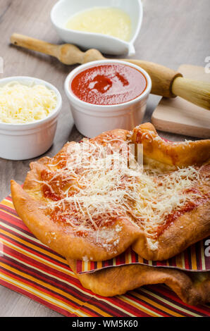 Traditional carnival fast food specialty, fried yeast dough with cheese, ketchup and garlic Stock Photo