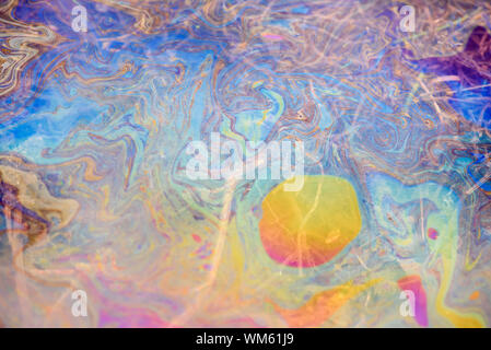 Toxic colours of oil and water in a chemical spill creating a psychedelic blur of rainbow colours. Copyspace area for environmental and pollution base Stock Photo