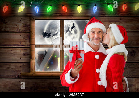 Festive couple against santa delivery presents to village Stock Photo