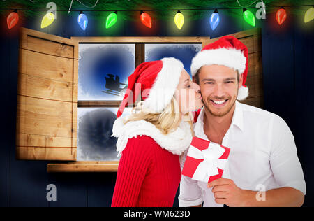 Young festive couple against santa delivery presents to village Stock Photo