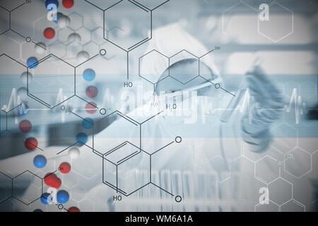 Chemist working cautiously with liquid and futuristic interface showing formula against dna helix in blue and red with ecg line Stock Photo