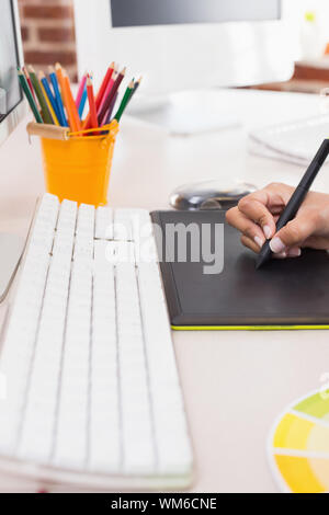 Close up side view of hand using digitizer in the office Stock Photo