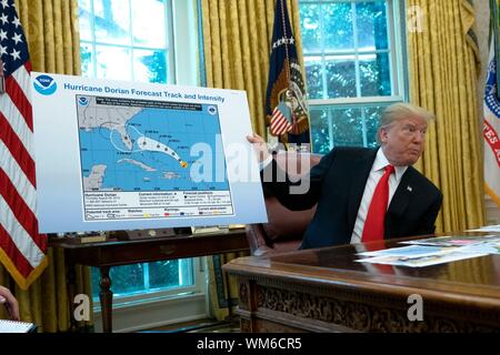 United States President Donald J. Trump holds a map that appears to show the course of Hurricane Dorian going through part of Alabama during a meeting at the White House in Washington, DC, U.S. on September 4, 2019. The hurricane is expected to hit a number of east coast states this week. Credit: Stefani Reynolds/CNP | usage worldwide