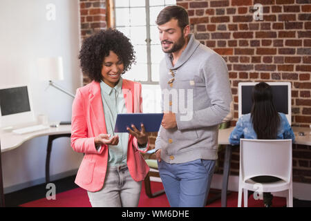Young casual colleagues using digital tablet in the office Stock Photo