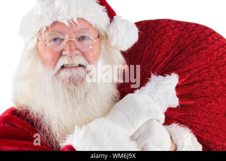 Jolly Santa carries his sack on white background Stock Photo