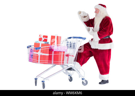 Santa pushes a shopping cart while reading on white background Stock Photo