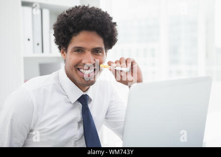 Portrait of a smiling businessman holding cigarette in his office Stock Photo
