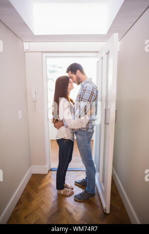 Cute couple standing in the hall in their new home