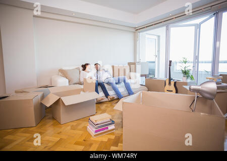 Cute couple taking a break from unpacking in their new home Stock Photo
