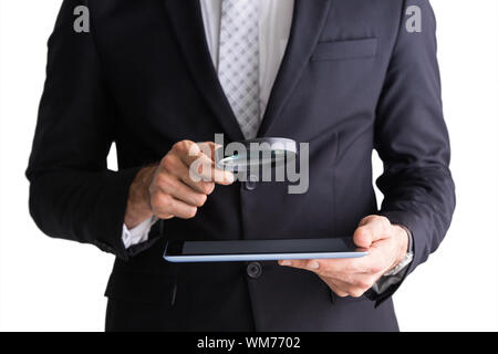 Businessman using magnifying glass and tablet on white background Stock Photo