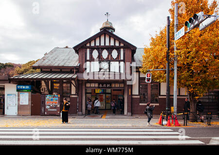 DEC 5, 2019 Tokyo, Japan - Harajuku station vintage building with people on sidewalk, pedestrain crosswalk and yellow Gingko tree in front of station Stock Photo