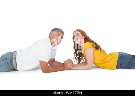 Casual couple lying and looking up on white background Stock Photo