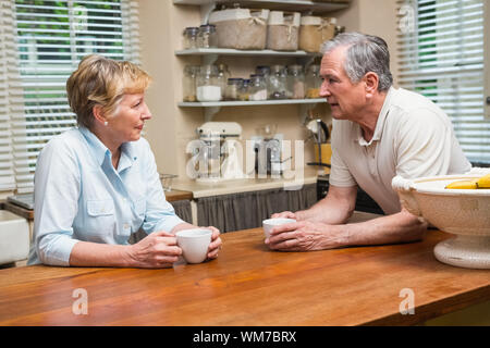 Senior couple having coffee together at home in the kitchen Stock Photo