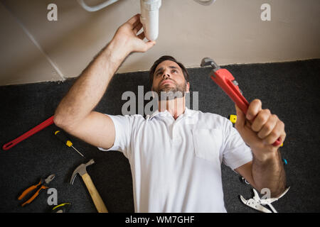 Plumber fixing the sink in a bathroom in a new house Stock Photo