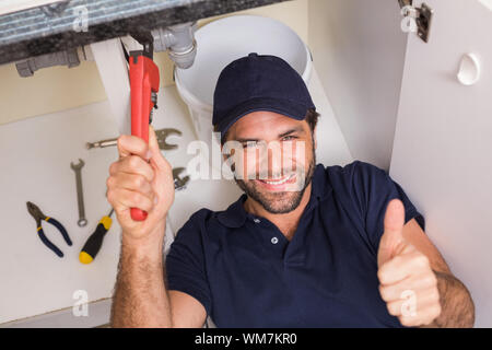 Plumber fixing under the sink in the kitchen Stock Photo