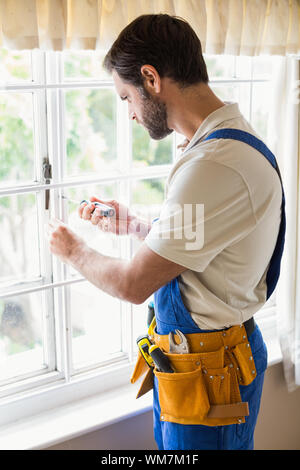 Handyman fixing a window in a new house Stock Photo